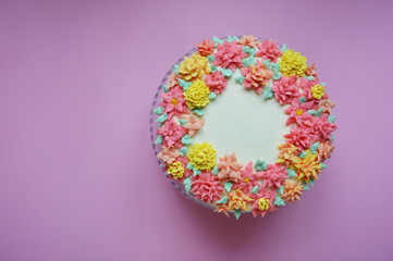cake with cream flowers on pink background