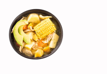 Traditional Colombian ajiaco served on black ceramic dish