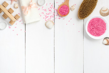 Frame of pink bath salt, towel, spa brush, massager on wooden table. Banner mockup with copy space for spa salon, body care concept, flat lay, top view, overhead
