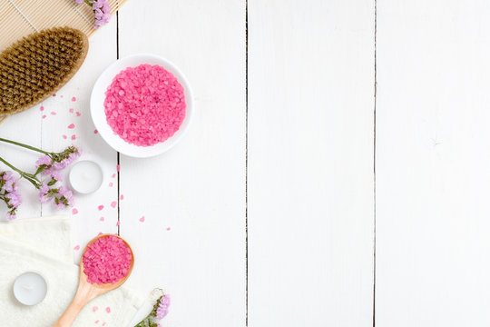 Pink Bath Salt With Natural Spa Products, Bath Tools, Flowers On White Wooden Surface. High Angle View, Flat Lay Style, Copy Space For Text