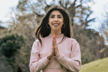 Attractive young woman enjoying her time outside in park with thanks with the expression on face
