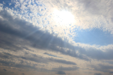 Fototapeta na wymiar bright sun rays make their way through white clouds