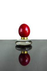 red egg on a brass ring with reflection isolated on white