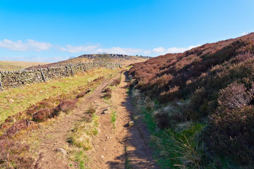 A stone wall runs alongside the footpath to Higger Tor