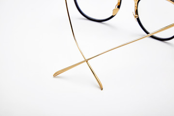 Golden framed glasses on white background
