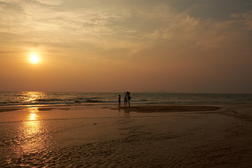 Sunset on the beach of Thailand in Pataeia with silhouettes of boats and people