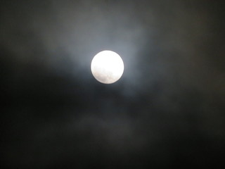 Naklejka na ściany i meble Beautiful Moon surrounded by clouds difficult to focus on