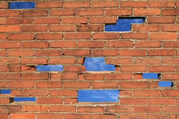 Backsteinmauer mit L&uuml;cken L&ouml;cher Himmel blau Hintergrund