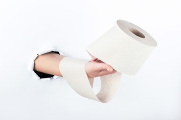 Female hand out of the hole in the paperman, holding a roll of toilet paper. Isolate on white background.