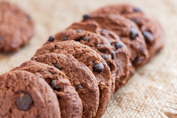 Chocolate chip cookies on sackcloth on the table.