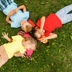 Happy children lying on grass in park