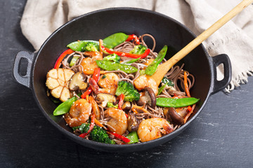 Stir fried noodles with shrimps and vegetables in a wok