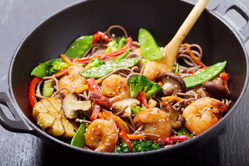 Stir fried noodles with shrimps and vegetables in a wok