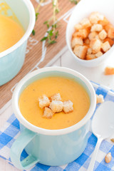 Pumpkin soup in a blue enameled mug, selective focus