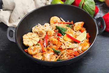 Stir fried noodles with shrimps and vegetables in a wok