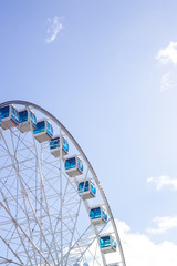 Beautiful blue and white colored ferris wheel against the sky with copy space 