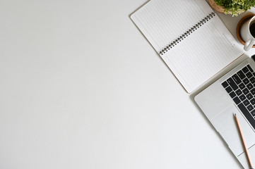 Office desk top view laptop computer, coffee, notebook paper and pencil on copy space.