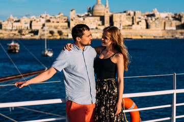 Man and woman embrace, Valletta and sea on backround