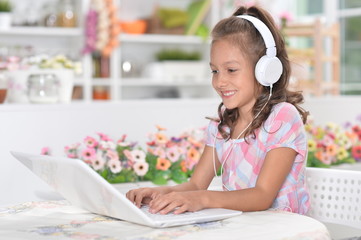 Portrait of girl in headphones using laptop