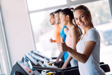 Pretty girl working out in a treadmill at the gym