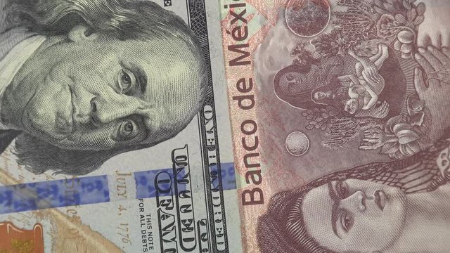 Mexico peso against US dollar bill rotating. Mexico and USA trade. 4K stock video footage