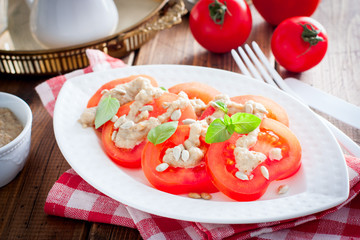 Sweet tomato salad with sunflower seed sauce, selective focus