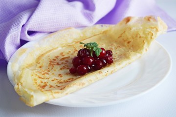 Delicious homemade pancakes with fresh berries on a white background.