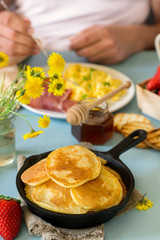 Pancakes with scrambled eggs and ham for breakfast