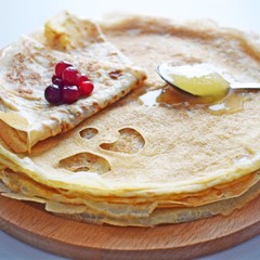 Delicious homemade pancakes with honey and fresh berries.