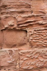 Close up image of old textured sandstone brickwork worn by the wind on an English  castle