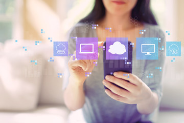 Cloud computing with woman using her smartphone in a living room