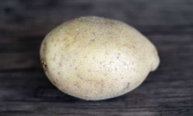 Fototapeta na wymiar Yellow potatoes on wood background.