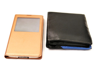 Items man use every day, wallet and smart phone on a light background.