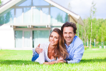 Happy couple laying in home garden