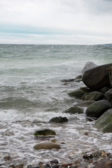 Fototapeta na wymiar View of the baltic sea and stone beach, stormy sea waves 
