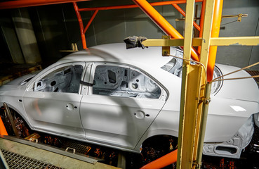The car frame in the automobile manufacturing plant is being dyed