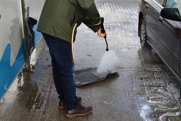 Fototapeta na wymiar Contactless car wash self-service. Young man washing his car spring.