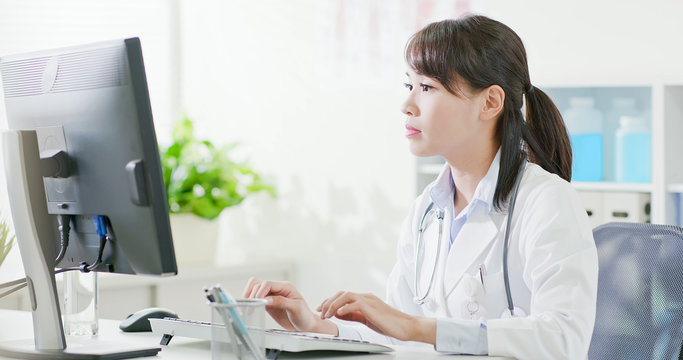 Woman Doctor Type On Computer