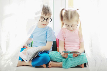 Children lie on the bed next to the newborn baby, little sister.