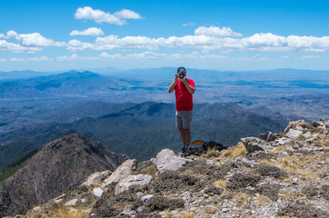 Obraz premium Mount Wrightson/USA - 11 May 2013: a photographer on top of the mountain