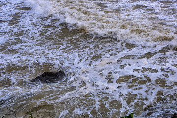 Sea waves breaking on a rocks. Deep blue sea waves hit cliff, hit rocks cliff. Mighty sea waves breaking on a cliff, splashing over rocks. Strong ocean waves hitting rocks.