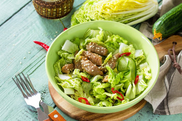Diet menu. Healthy salad with Chinese cabbage, chicken, sesame and chili pepper on wooden table.