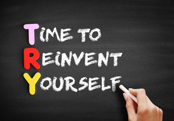 Color Wooden alphabets building the word TRY - Time to Reinvent Yourself acronym on blackboard