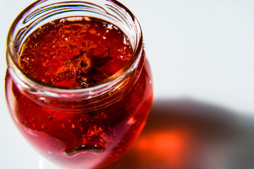Strawberry in red jelly. Perfect for background. Around the strawberry there are air bubbles from the solid jelly. Focus on jelly. Macro shot