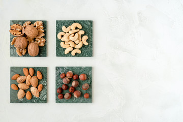 Various nuts selections . Hazelnut , almond, walnut , cashew on green marble surfaces. Top view with space for text