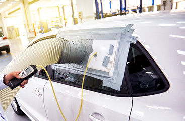 In the automobile manufacturing plant, engineers are using professional instruments to test the sealing effect of the car.