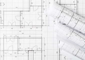 Rolls of architectural blueprint house building plans on blueprint background flat lay