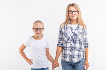 Fototapeta premium Happy young mother and laughing kid in fashion glasses have fun on white background