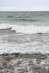 View of the baltic sea and stone beach, stormy sea waves 