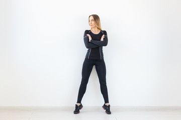 People, fitness and sport concept - Beautiful fit woman dressed in sportswear posing over white background